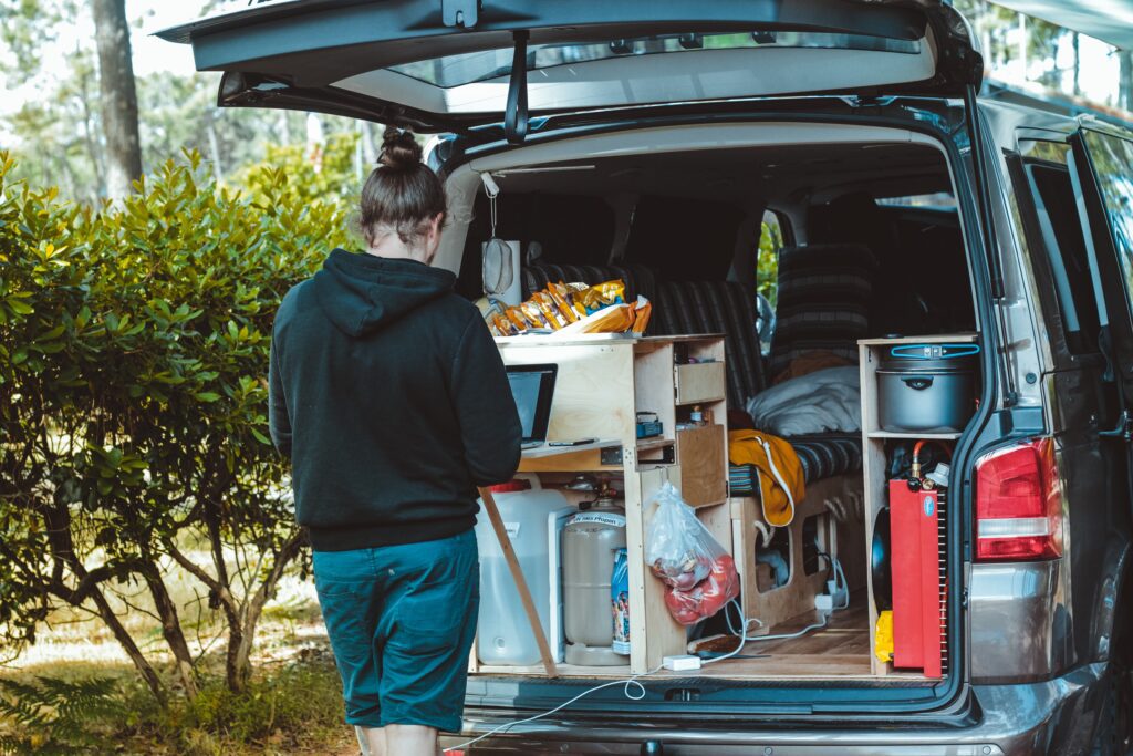 Man working on laptop in the back of his vanlife van.