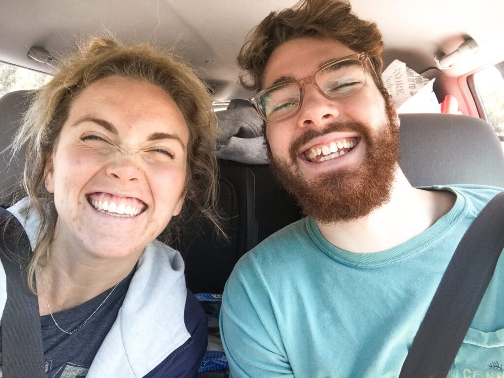 Ellie and Tyler smiling in the car during our cross-country road trip.