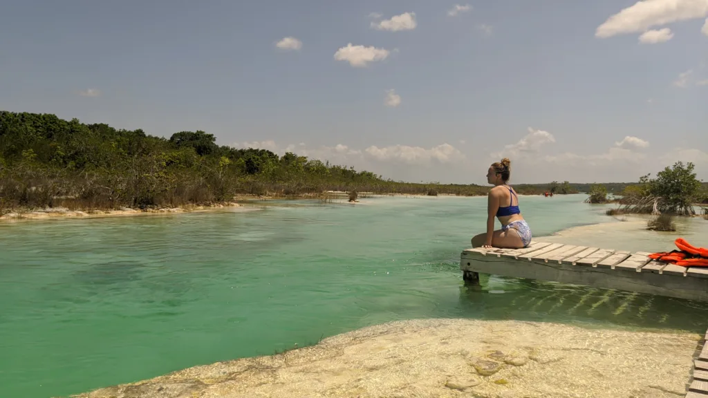 Ellie Sitting on a Pier at Los Rapidos, Bacalar. Things to do in Bacalar.